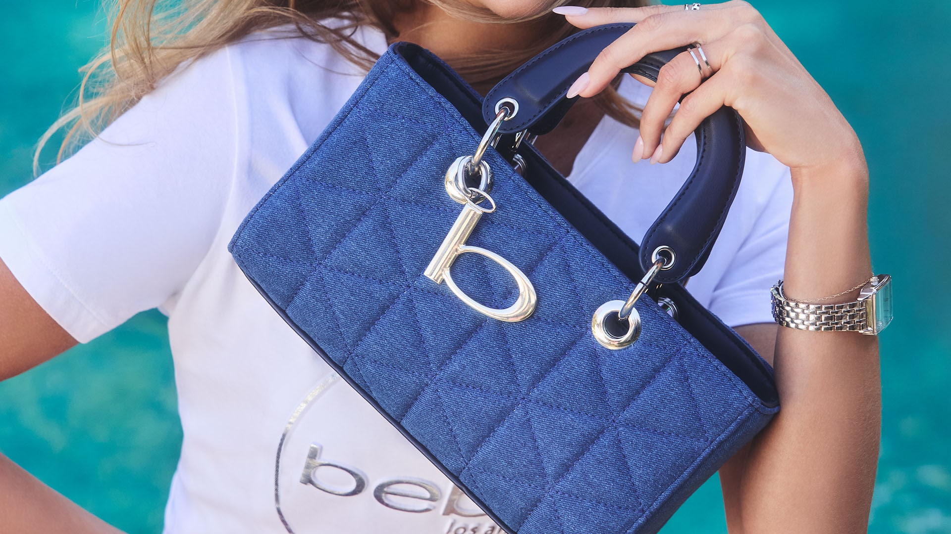 Acercamiento de modelo mujer mostrando una bolsa de la marca bebe.